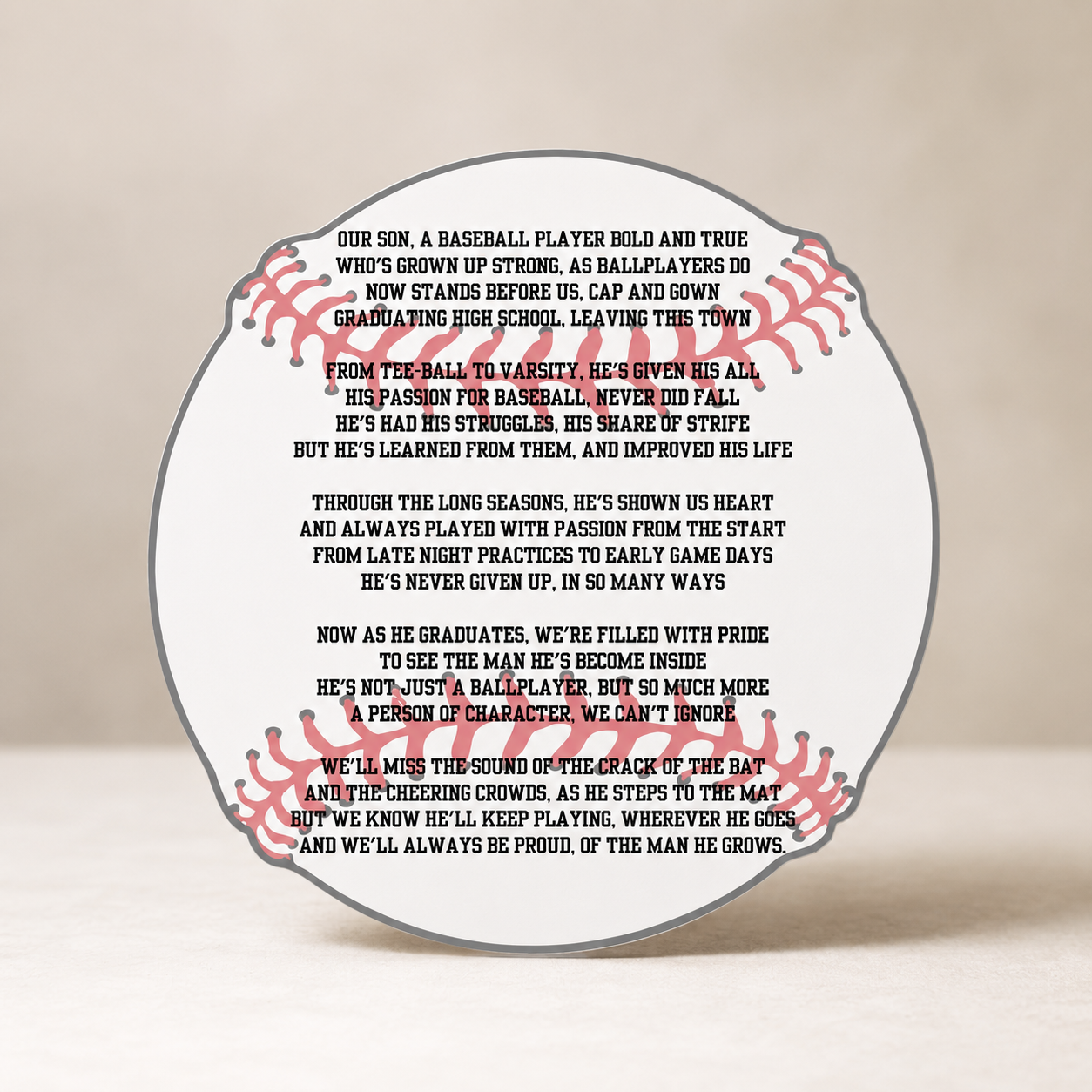 Baseball-shaped plaque with engraved text on a beige background