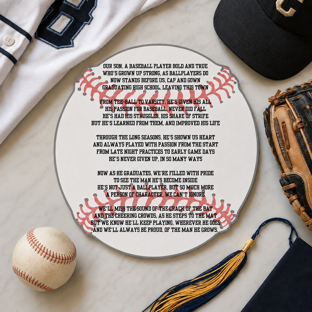 Graduation plaque with baseball-themed text, cap, glove, and ball on a marble surface